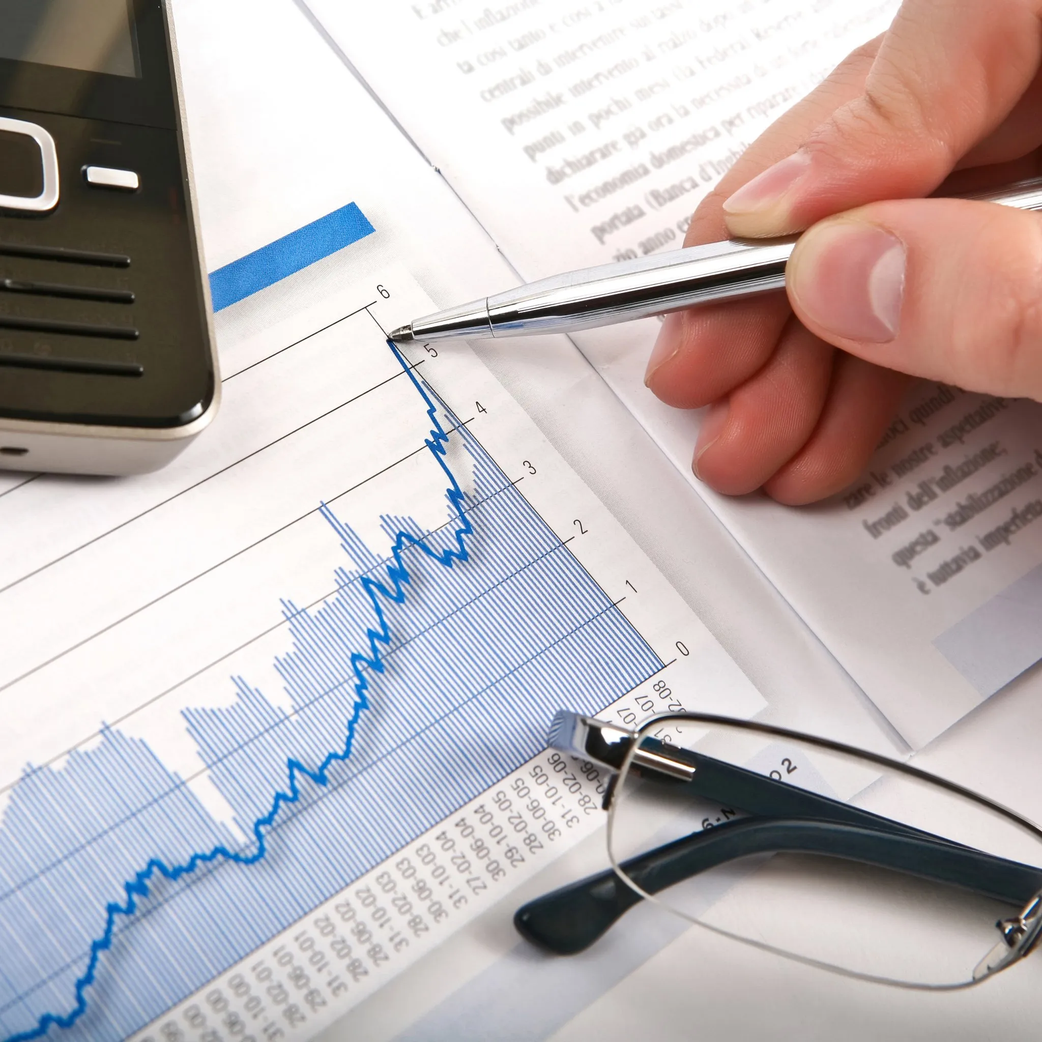 Žena sedí u stolu s kalendářem a kalkulačkou, plánuje splátky půjčky a škrtá splacené měsíce