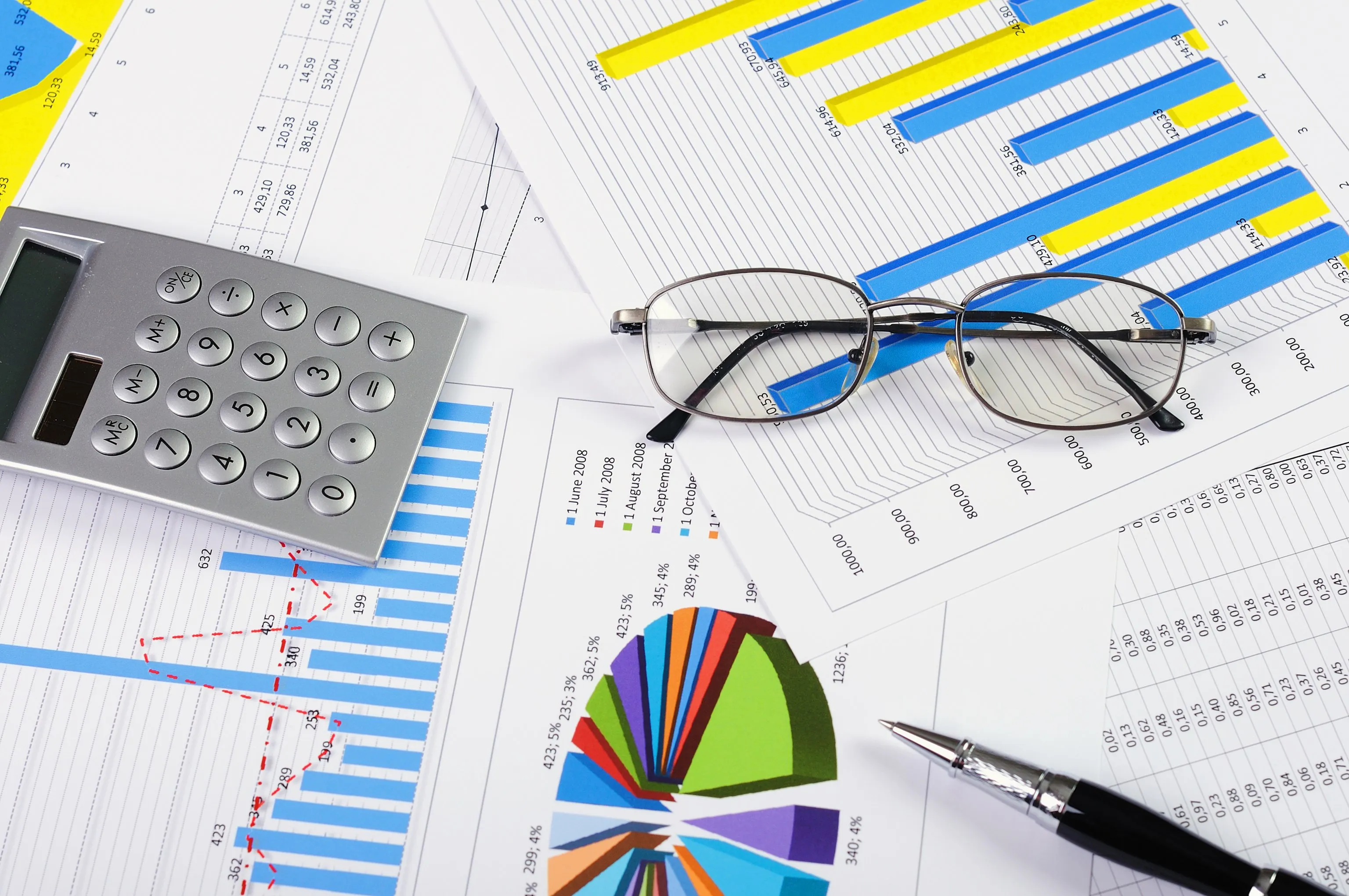 Ruce podepisující novou smlouvu o konsolidaci půjček na stole s kalkulačkou a dokumenty